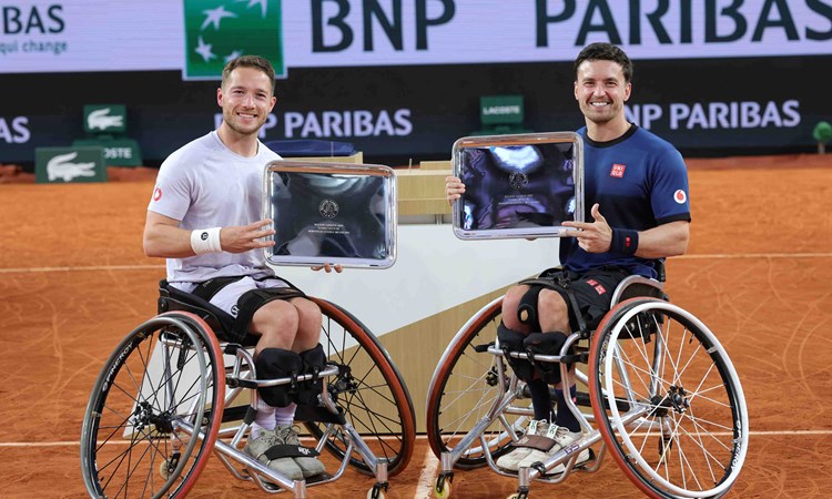 Alfie Hewett and Gordon Reid smiling while holding their winners trophies at Roland Garros